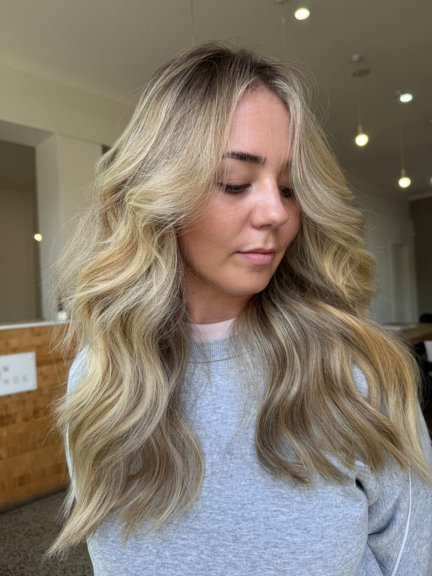 Woman with long, wavy blonde hair in an indoor setting