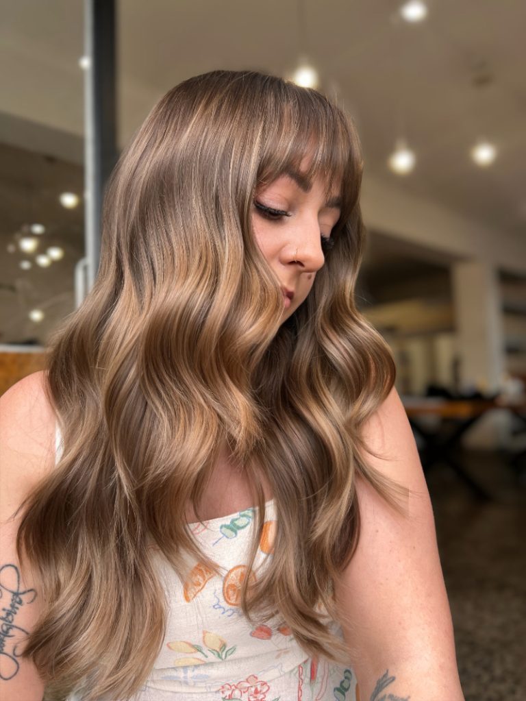 Woman with long, wavy hair in a casual setting
