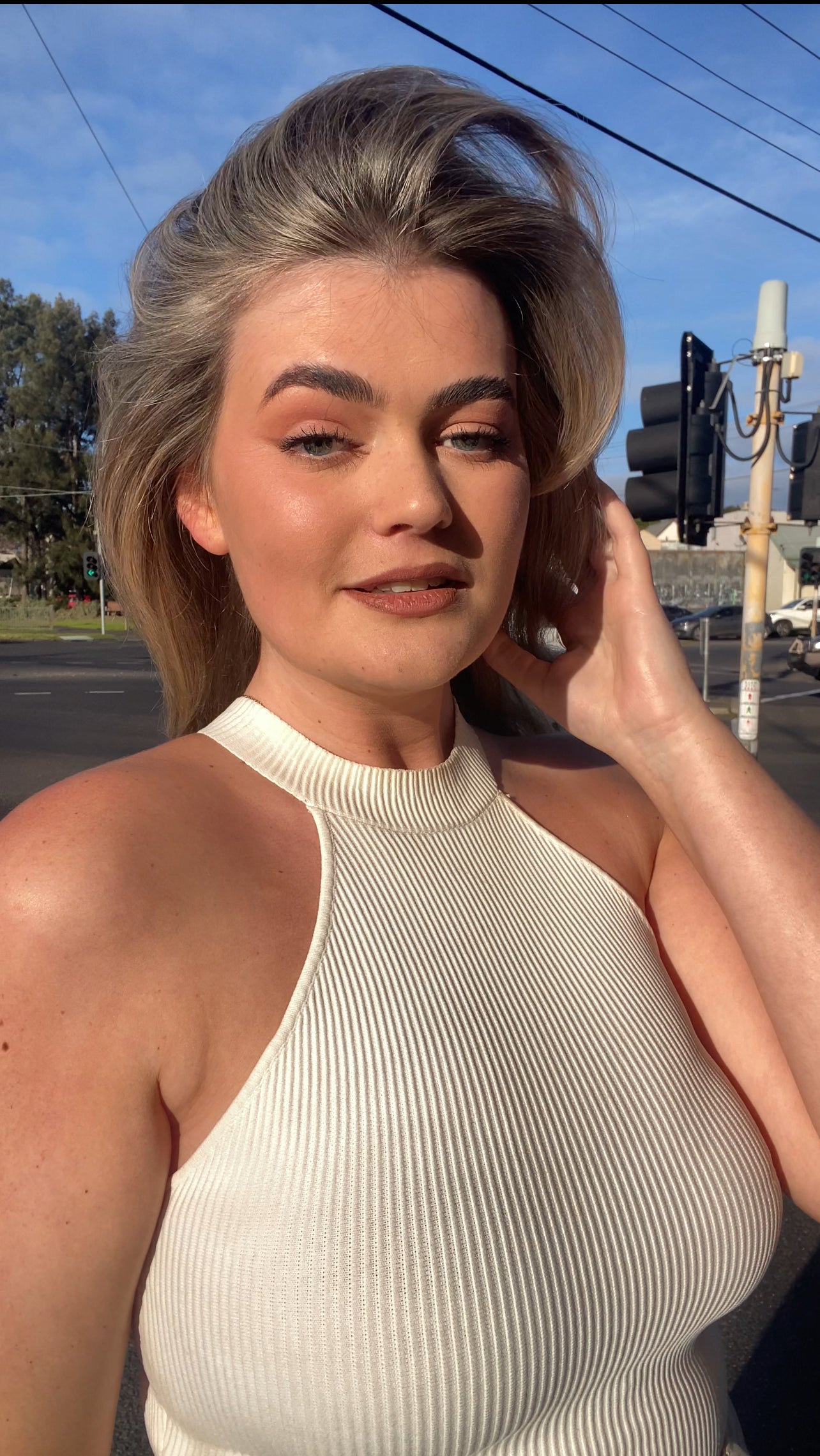 Woman in a white halter top outdoors on a sunny day