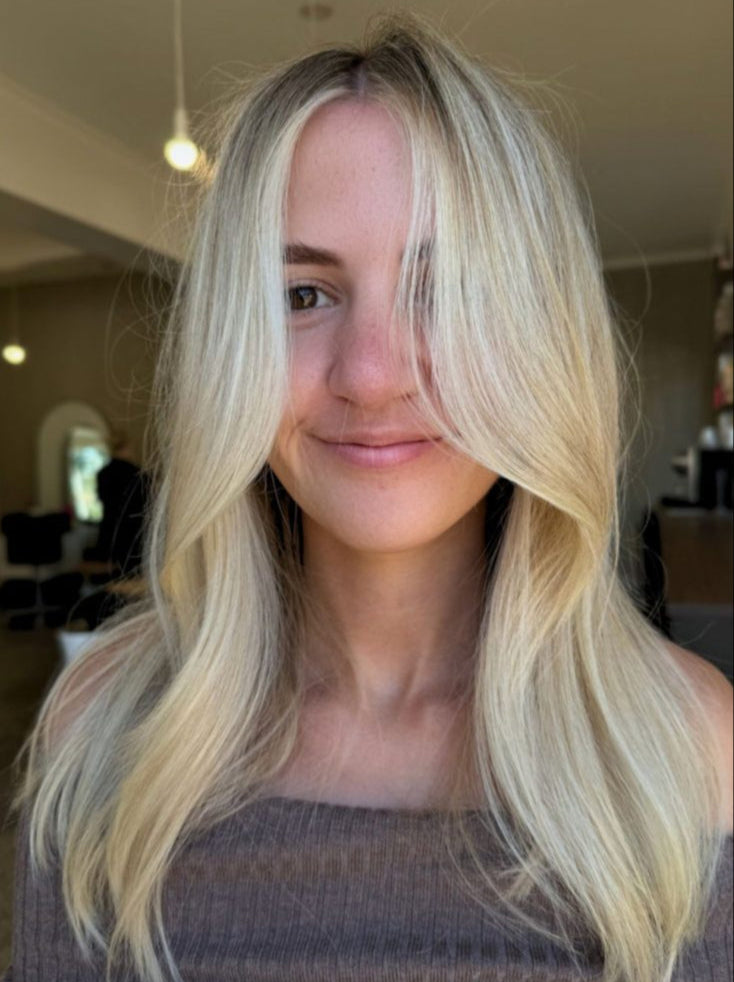 Person with long blonde hair in an indoor setting